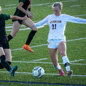 Two soccer players chase ball